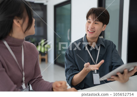 Two asian business worker looking at tablet discussing corporate strategy in teamwork, working on computer laptop in office at office Two asian business worker looking at tablet discussing corporate strategy in teamwork, working on computer laptop in office at office 105652754