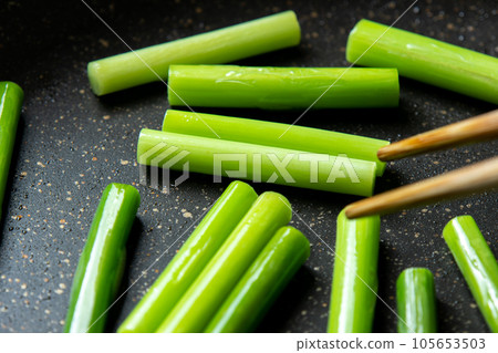 鍋裡炒蒜苗的烹飪場景。 鍋裡炒蒜苗的烹飪場景。 105653503