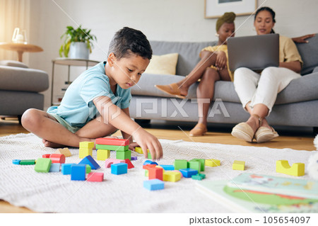 Play, toys and child on floor with parents on sofa for learning, development and education. Lgbtq family, home and boy with building blocks for fun, relax and games with lesbian mothers on laptop 105654097