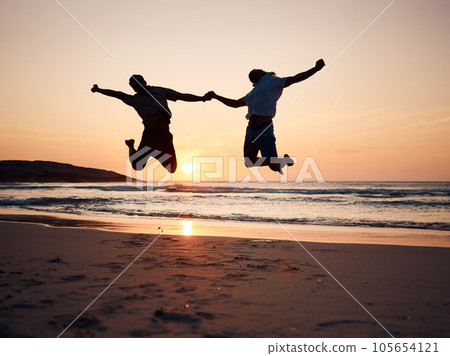 Beach, sunset and silhouette of couple jump, holding hands and enjoy fun quality time together on summer holiday. Energy, ocean sea and excited man, woman or people celebrate Australia vacation Beach, sunset and silhouette of couple jump, holding hands and enjoy fun quality time together on summer holiday. Energy, ocean sea and excited man, woman or people celebrate Australia vacation 105654121