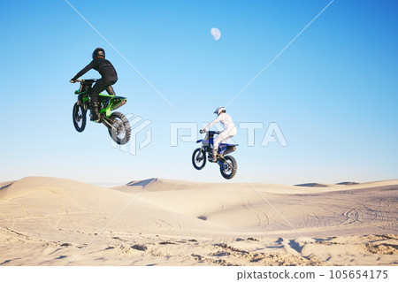 Motorcycle, desert and jump in sky, speed and competition at outdoor race for performance, goal or off road. Motorbike athlete, dune and ramp in nature, sand or together for training in mockup space 105654175