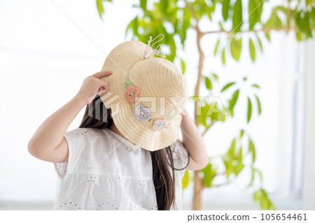 Portrait of a girl A girl hiding her face with a straw hat Portrait of a girl A girl hiding her face with a straw hat 105654461