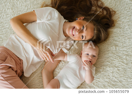 Top view of a Caucasian mother lying at home on a bed with her young son. Top view of a Caucasian mother lying at home on a bed with her young son. 105655079