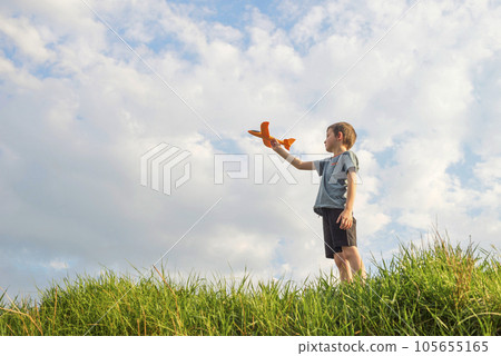 Little boy launches a toy plane into the air. Child launches a toy plane Little boy launches a toy plane into the air. Child launches a toy plane 105655165