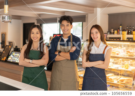Asian barista male and female colleagues standing with arm crossed and looking at camera and smiling at cafe shop. Happy working a small business together 105656559