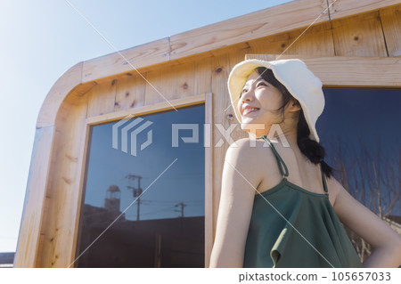 A young woman entering an outdoor sauna at a campsite Cabin style sauna Finnish outdoor sauna 105657033