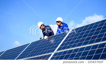 Technicians workers installing solar panels at solar cell farm Technicians workers installing solar panels at solar cell farm 105657697