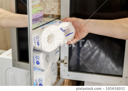 A man stocking up toilet paper at home. Crisis product lack concept A man stocking up toilet paper at home. Crisis product lack concept 105658031