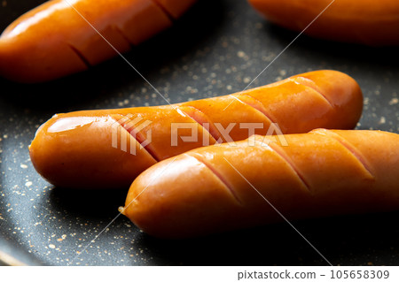 烹飪場景,將維也納香腸切入煎鍋中烘烤。 烹飪場景,將維也納香腸切入煎鍋中烘烤。 105658309