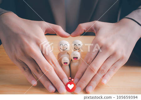 Woman's hands in the shape of a heart with a wooden doll inside. international day of families. hands protecting family. insurance, domestic violence, world mental health day, Family care concept. 105659394
