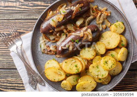Rustic food black pudding with fried potatoes and onions close-up on a plate. Horizontal top view Rustic food black pudding with fried potatoes and onions close-up on a plate. Horizontal top view 105659594