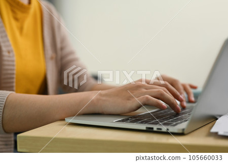 Closeup shot of unrecognizable woman hands typing on laptop. People, technology and communication 105660033