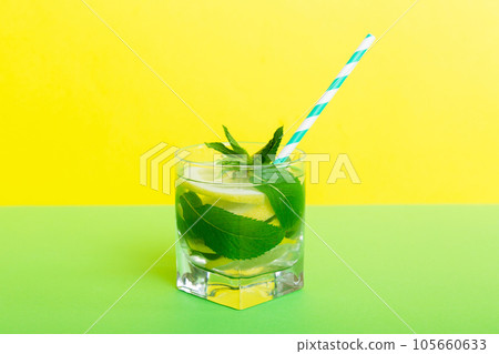 Mojito summer refreshing cocktail with ice and mint. mojito cocktail with lime, lemon and mint in a tall glass with a stick 105660633