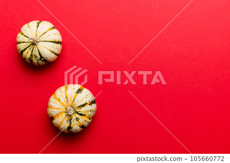 Autumn composition of little orange pumpkins on colored table background. Fall, Halloween and Thanksgiving concept. Autumn flat lay photography. Top view vith copy space 105660772