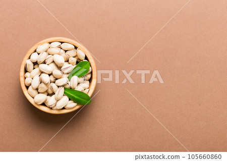 Fresh healthy Pistachios in bowl on colored table background. Top view Healthy eating concept. Super foods 105660860
