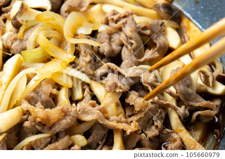 Stir-fried beef, onions, and king oyster mushrooms, close-up of the cooking scene. 105660979
