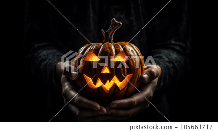Unrecognizable man holding jack-o-lantern in hands on dark night background. Halloween concept Unrecognizable man holding jack-o-lantern in hands on dark night background. Halloween concept 105661712