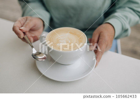 Closeup image of woman with Cappuccino coffee mugs in cafe 105662433