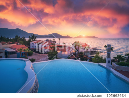 Beautiful swimming pool, sky with pink clouds at colorful sunset 105662684