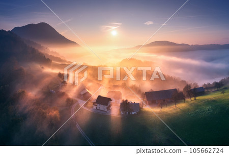 Aerial view of mountain village in orange low clouds at sunrise Aerial view of mountain village in orange low clouds at sunrise 105662724