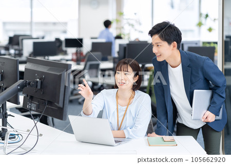 Male and female young engineers having a meeting while operating a personal computer in the office 105662920