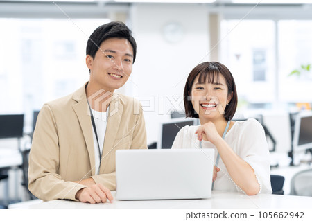 Male and female young engineers having a meeting while operating a personal computer in the office 105662942