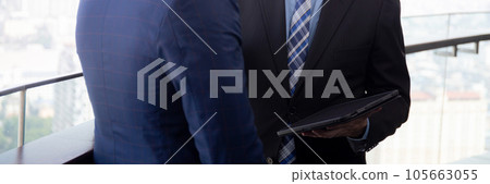 Senior businessman standing talking with partner and looking digital tablet together at office. Senior businessman standing talking with partner and looking digital tablet together at office. 105663055