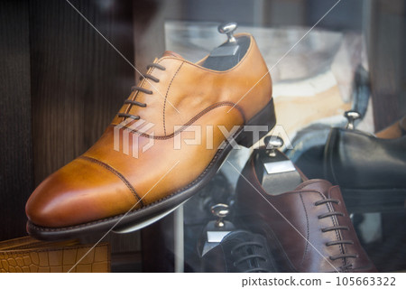 Closeup of brown leather shoes for men in a luxury fashion store showroom Closeup of brown leather shoes for men in a luxury fashion store showroom 105663322