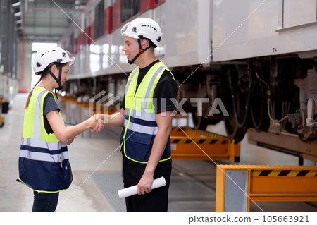 Young caucasian engineer man and woman hold blueprint meeting and checking electric train. Young caucasian engineer man and woman hold blueprint meeting and checking electric train. 105663921