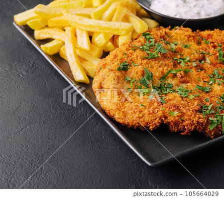 Fried wiener schnitzel from veal topside with french fries Fried wiener schnitzel from veal topside with french fries 105664029