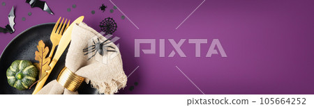 Halloween table setting with cutlery and decorations on purple background banner Halloween table setting with cutlery and decorations on purple background banner 105664252