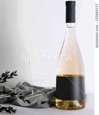 Wine glass and bottle of white wine 105664337