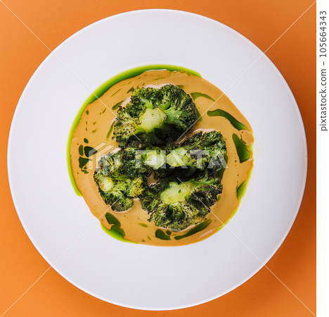 Pumpkin cream soup with broccoli on plate 105664343