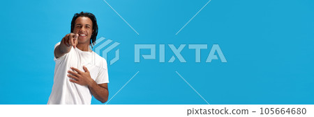 You. Young smiling african man in white t-shirt pointing at camera and smiling against blue studio background 105664680