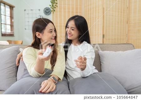 Asian lesbian woman couple enjoy watch TV together in house and feel happy watch movie on television. Homosexual-LGBTQ concept. 105664847