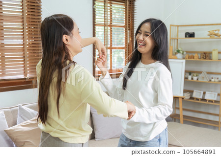 Loving LGBTQIA lesbian gay couple enjoy dancing together in the living room. Homosexual-LGBTQ concept. Loving LGBTQIA lesbian gay couple enjoy dancing together in the living room. Homosexual-LGBTQ concept. 105664891