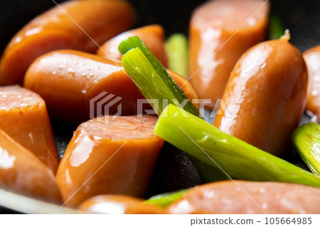 A cooking scene where wiener sausage and garlic sprouts are fried in a frying pan. A cooking scene where wiener sausage and garlic sprouts are fried in a frying pan. 105664985