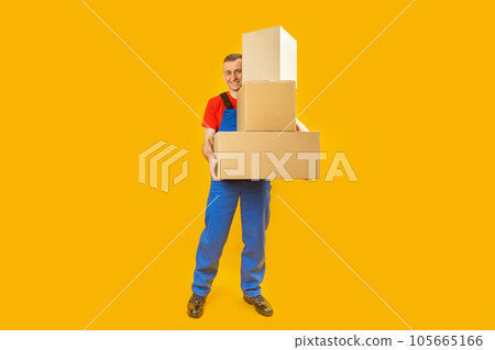 Loader or courier with parcels. Young man in uniform with several large boxes. Copy space, mock up. Loader or courier with parcels. Young man in uniform with several large boxes. Copy space, mock up. 105665166
