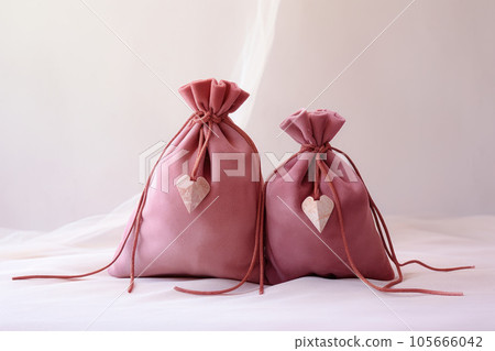 Pink suede fabric bags with laces for jewelry are on the table Pink suede fabric bags with laces for jewelry are on the table 105666042