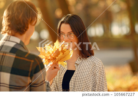 Couple in a park. Guy in a white t-shirt. Golden autumn. Couple in a park. Guy in a white t-shirt. Golden autumn. 105667227