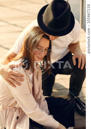 Couple by the water. Guy in a white t-shirt. Pair on a sunset background. 105667238
