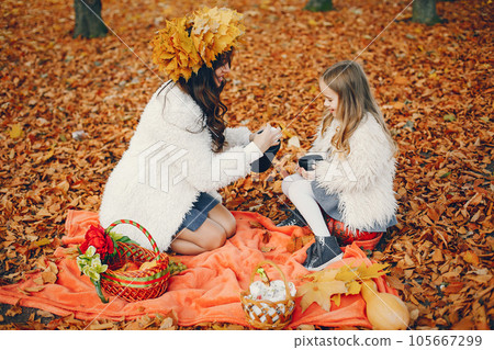 Beautiful mother with daughter. Family in a autumn park. Golden autumn Beautiful mother with daughter. Family in a autumn park. Golden autumn 105667299