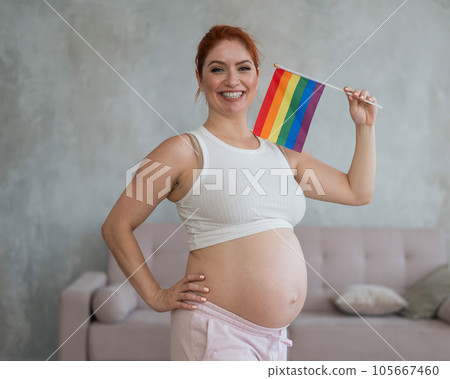 Happy pregnant woman holding a rainbow flag. Happy pregnant woman holding a rainbow flag. 105667460
