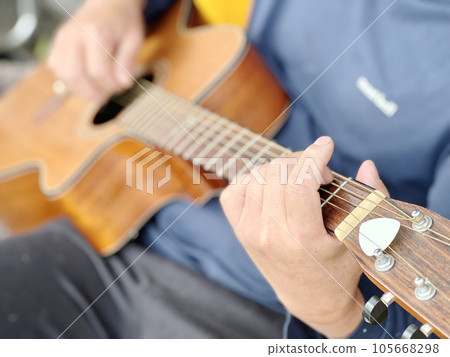 Hand of a man playing the guitar 105668298