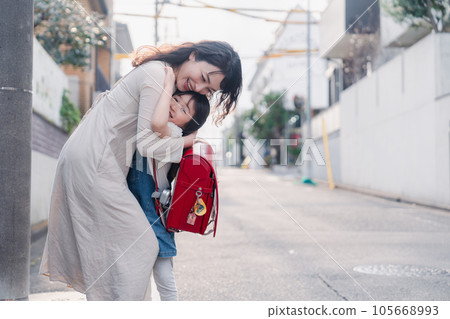 A mother picking up an elementary school girl 105668993