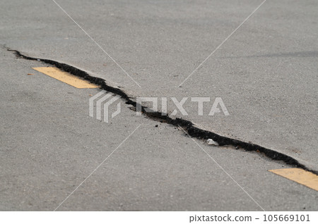 Selective focus on broken pavement road.Broken pavement road background and texture. Selective focus on broken pavement road.Broken pavement road background and texture. 105669101