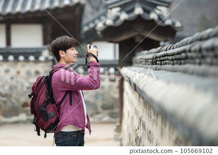 A young man holding a camera and taking pictures during a trip to Korea A young man holding a camera and taking pictures during a trip to Korea 105669102
