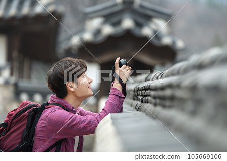 A young man holding a camera and taking pictures during a trip to Korea A young man holding a camera and taking pictures during a trip to Korea 105669106