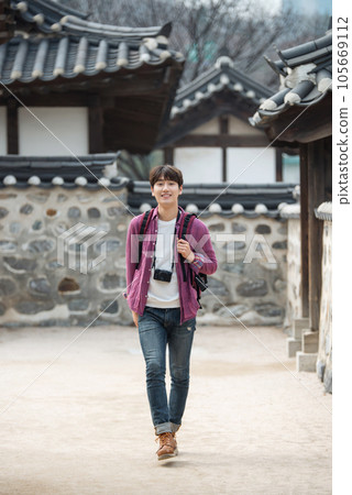 A young man holding a camera and taking pictures during a trip to Korea 105669112