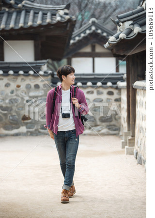 A young man holding a camera and taking pictures during a trip to Korea 105669113